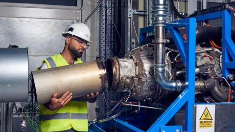 Ross Jarman Ihab Amed working on the test jet engine. He's connecting a metal tube to another piece of equipment