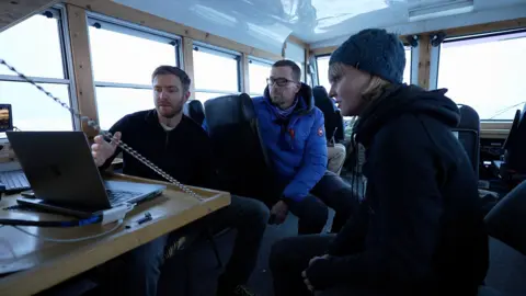 Kevin Church/BBC Polar Bears International scientists Flavio Lehner (left) and Geoff York with BBC science correspondent Victoria Gill on board a tundra buggy near Churchill, Manitoba 