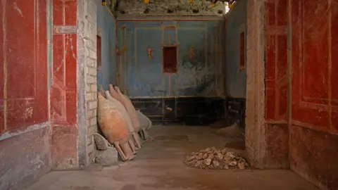 Tony Jolliffe/BBC Small blue room used for prayer. A pile of oyster shells lie on the floor on the right