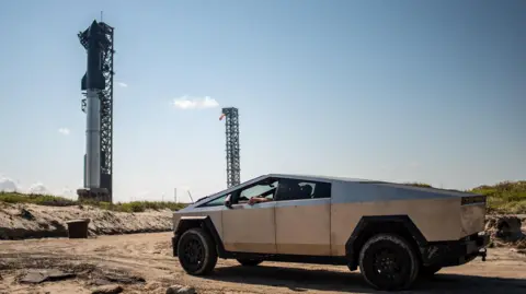 Sergio Flores/AFP/Getty Images A Tesla Cybertruck faces the SpaceX Starship as it sits on a launch pad at Starbase near Boca Chica, Texas, on October 12, 2024, ahead of the Starship Flight 5 test.