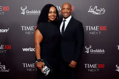 Getty Images Victor Glover wears a suit and tie while posing next to an unnamed woman on the red carpet as he attends the 2023 Time100 Next at Second on October 24, 2023 in New York City.
