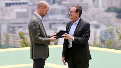 PA Media Prince William is presented with the keys to the city by the Mayor of Rio de Janeiro, Eduardo Paes, during a 'Welcome to Rio' event at Sugarloaf Mountain, in Rio de Janeiro,