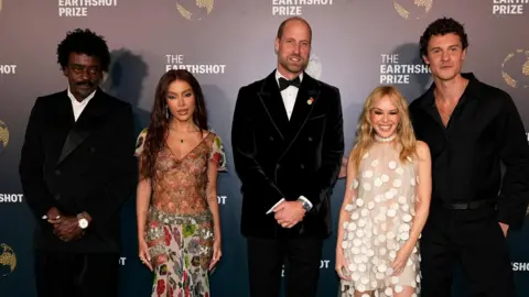 PA Media Seu Gorge, Anitta, the Prince of Wales, Kylie Minogue and Shawn Mendes pose for a photo in smart evening attire.