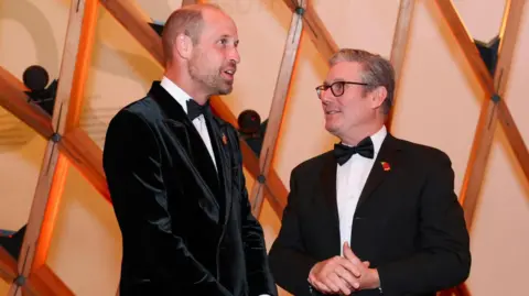 Reuters The Prince of Wales and Prime Minister Sir Keir Starmer, both wearing dark dinner jackets and bow ties, talk with each other at an event.